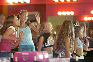 Singing karaoke and mugging for the camera are, from left, Claire Benninghoff, Rachel Beard, Kaley Wojciechowski, 8, and Jillian Herrera, far right, watch themselves on the catwalk at Sweet & Sassy.