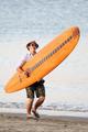 Kevin Jonas on the beach with a surfboard - the-jonas-brothers photo