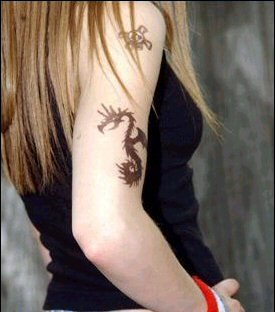 Yes, Avril Lavigne has 4 tiny tattoos only. 
One on her left wrist (First one) 
One on her right leg 
One one on her right wrist 
And one on her left hip (Newest one)
lol!! these r new one but first she was having tatoos on her arm also u can see in the pic i have added!! with this response!!