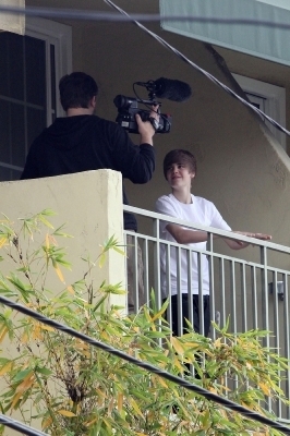  Justin Hangs on his balcony while someone is filming him